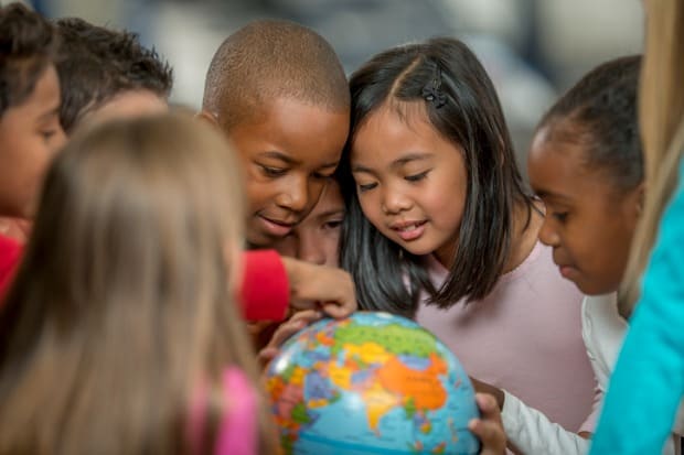 crianças brincando com globo terrestre